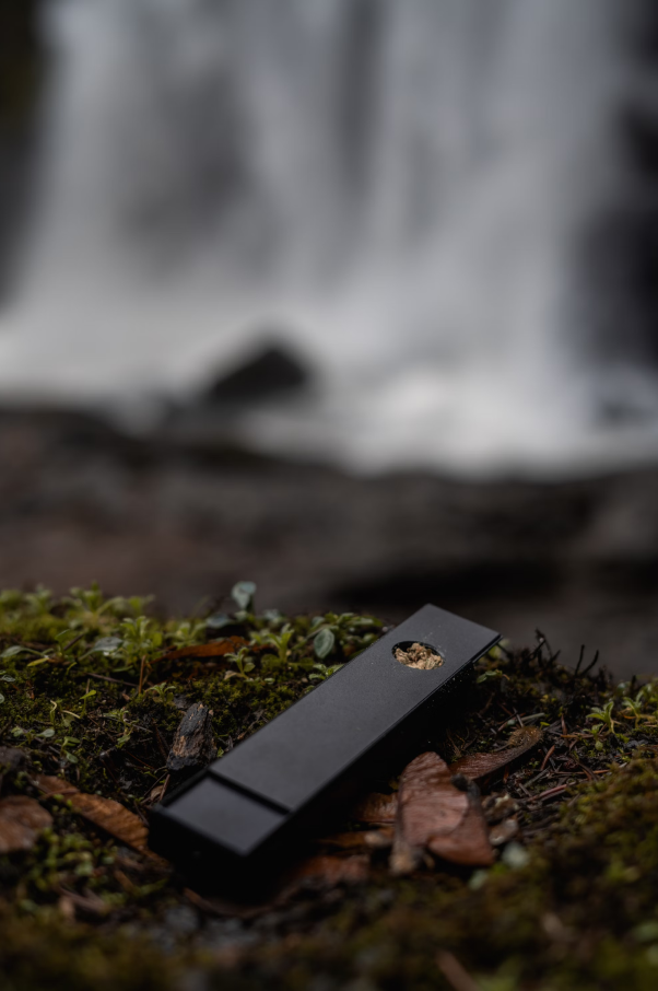 A nature scene with a bowl loaded with cannabis ready to smoke in the foreground. 