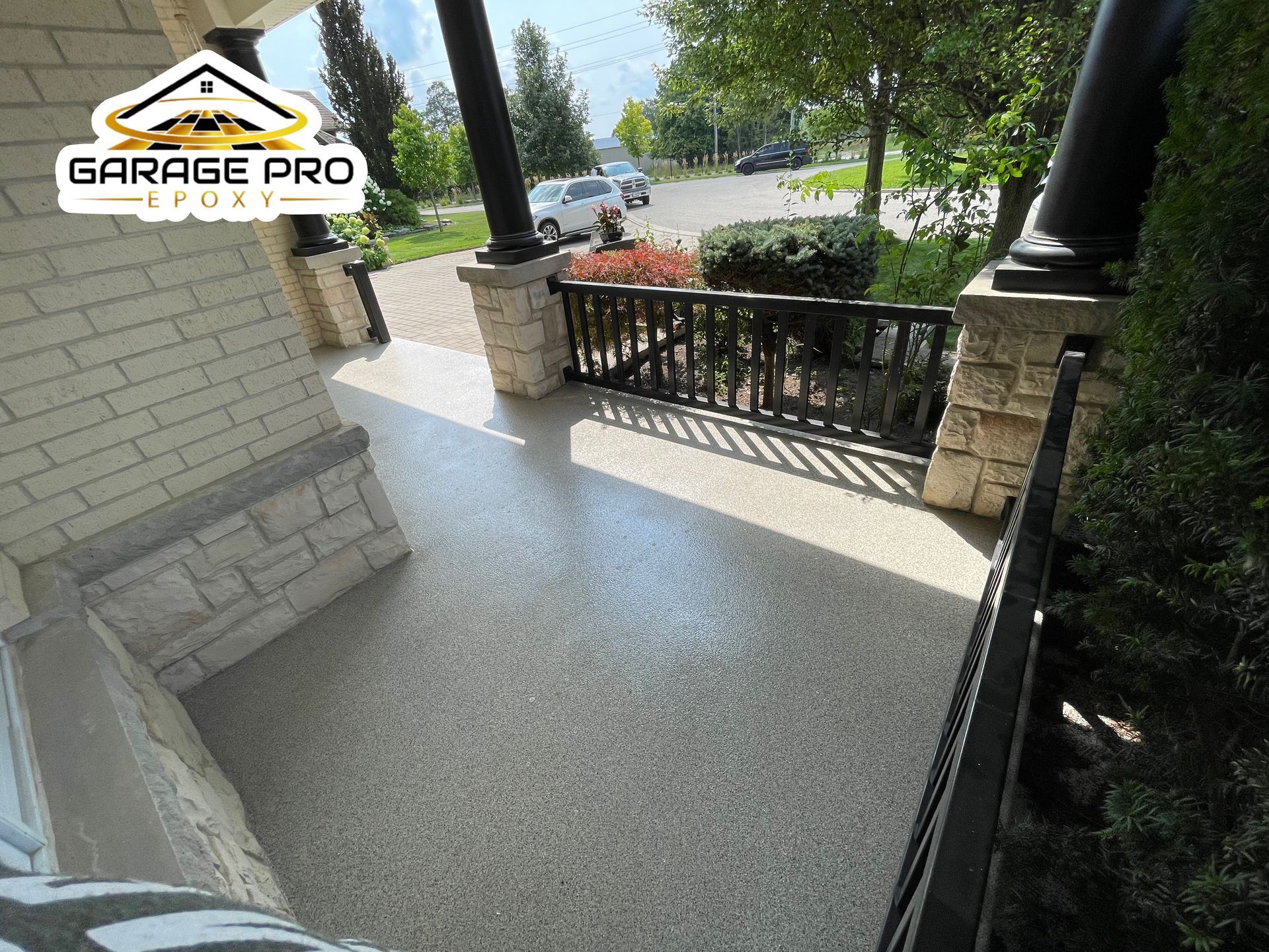 A porch with a railing and a concrete floor.