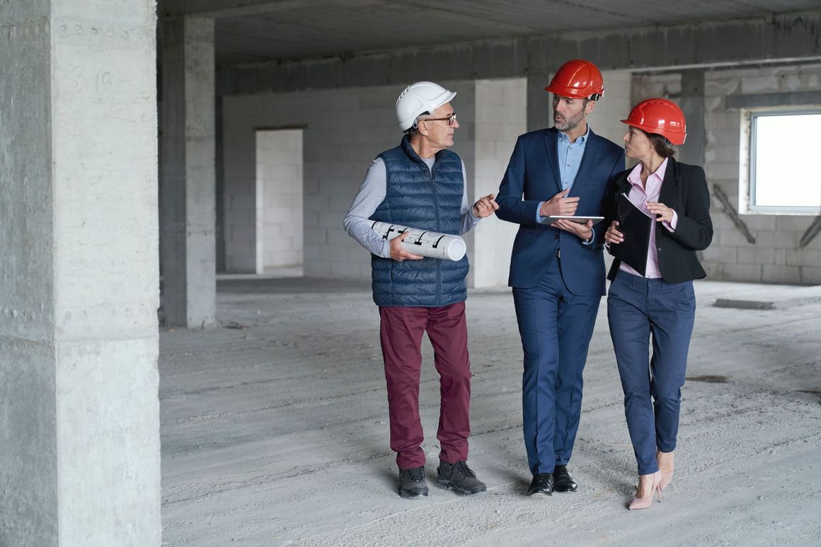 A group of people are standing in a building under construction.