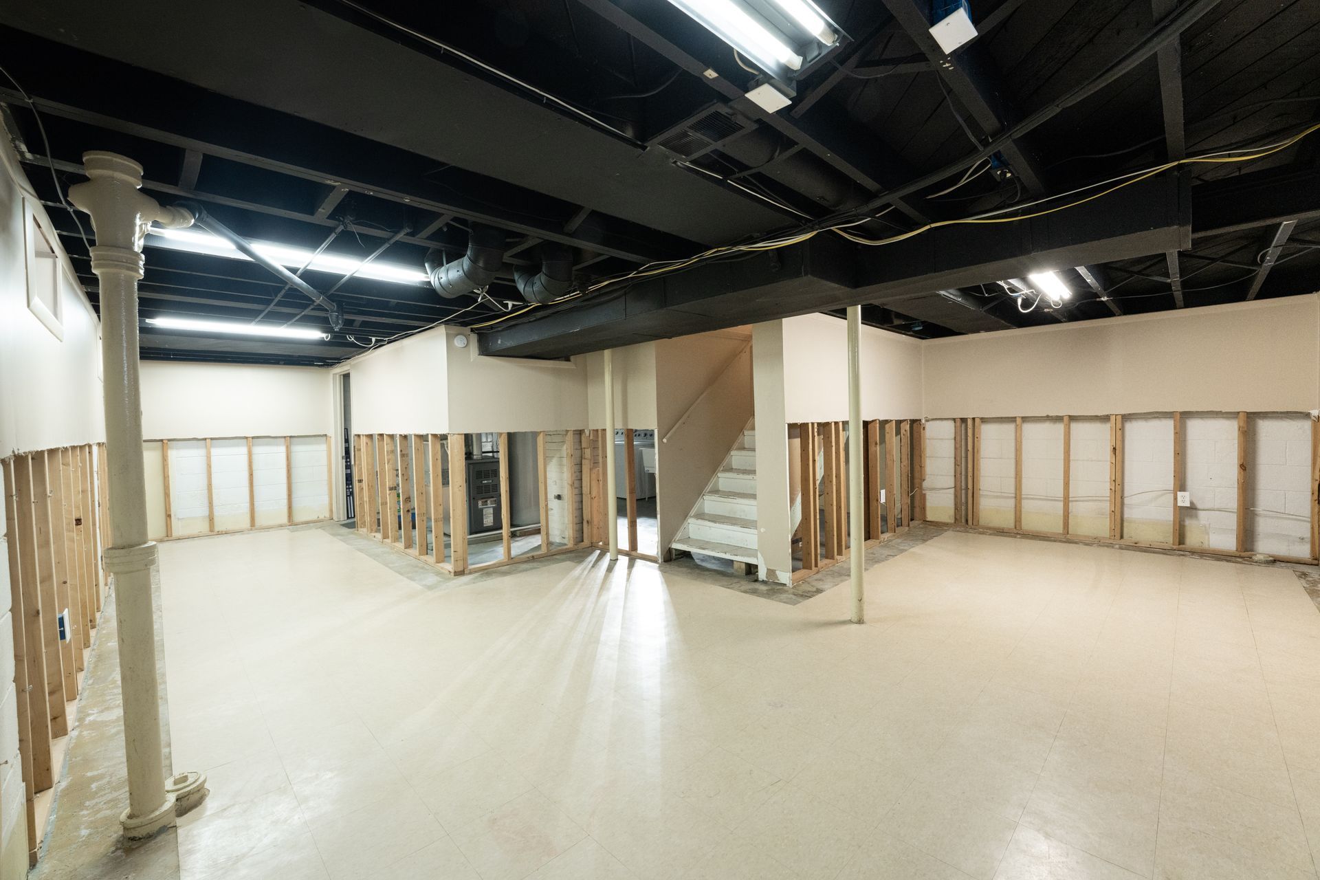 An empty basement with concrete walls and windows.