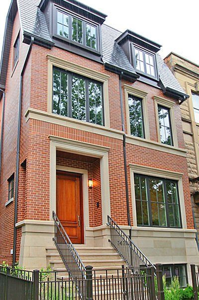 A large brick house with stairs leading up to the front door