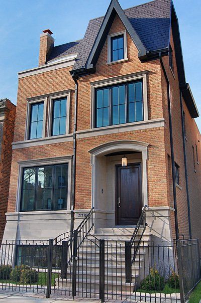 A large brick house with stairs leading up to the front door