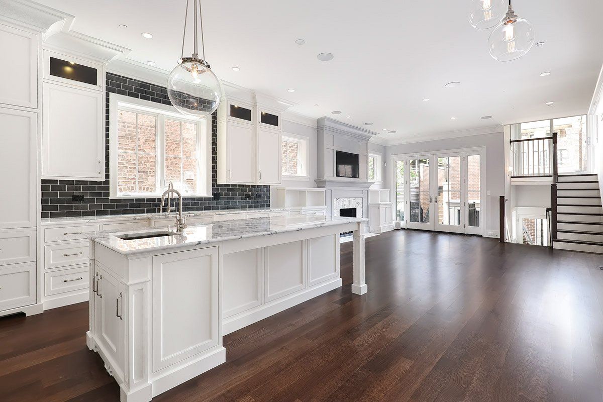 A kitchen with white cabinets and a large island in the middle of the room.