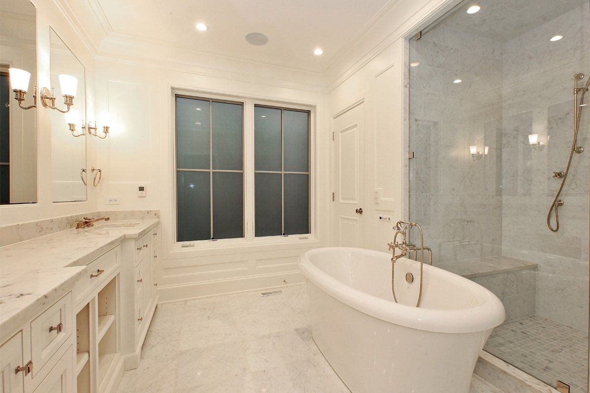 A bathroom with a tub , sink , and shower.