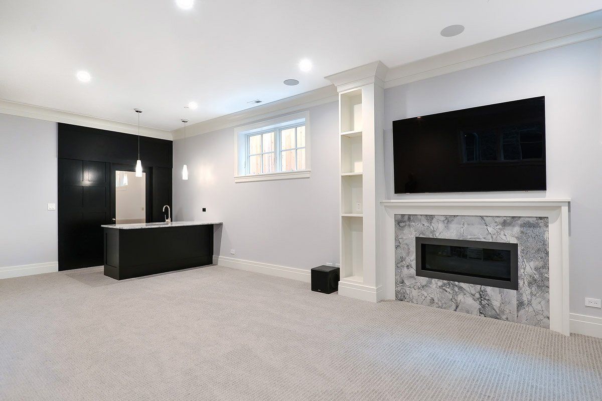 A living room with a fireplace and a flat screen tv on the wall.