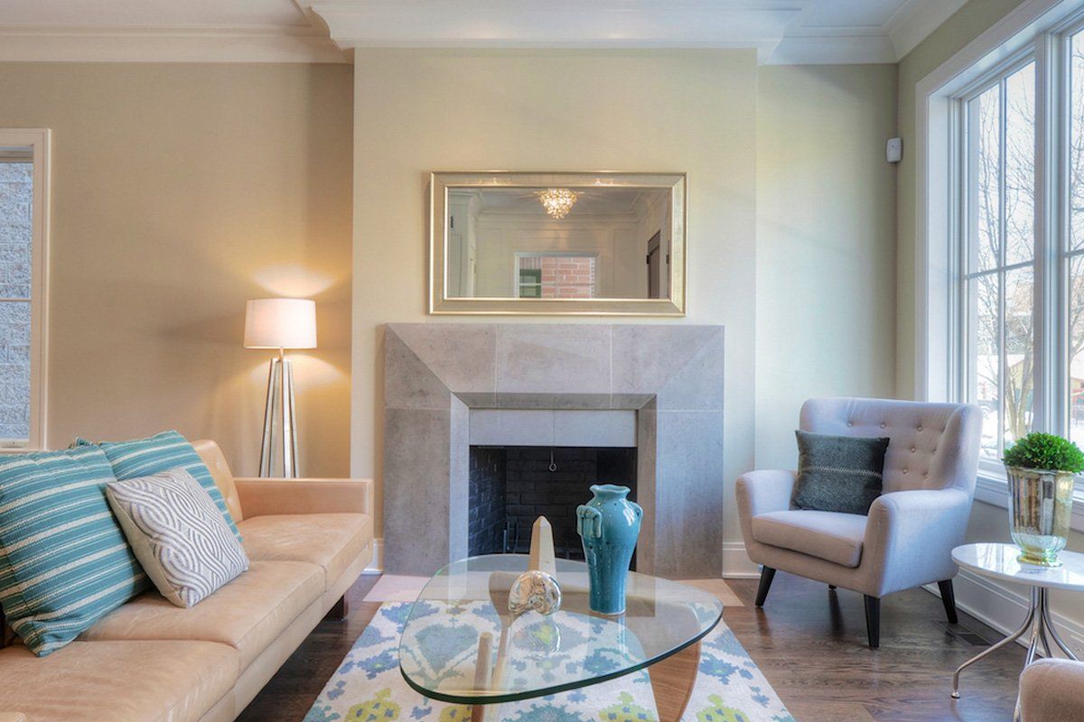 A living room with a couch , chair , coffee table and fireplace.