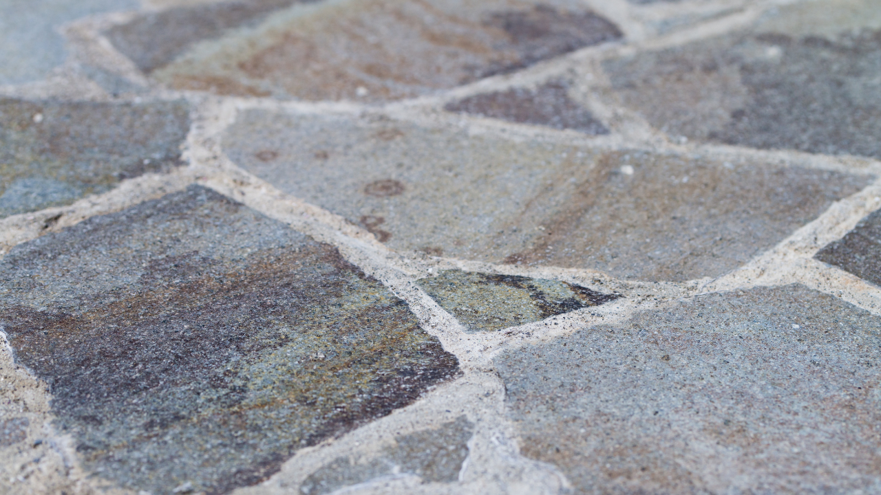 Close-up of stone patio with irregular shapes and light gray grout.