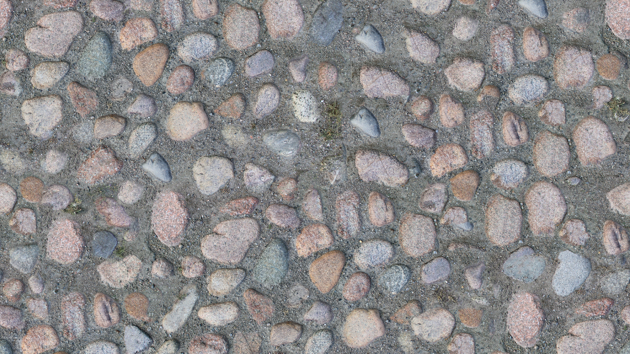 Cobblestone pavement with mixed-color stones set in gray mortar.