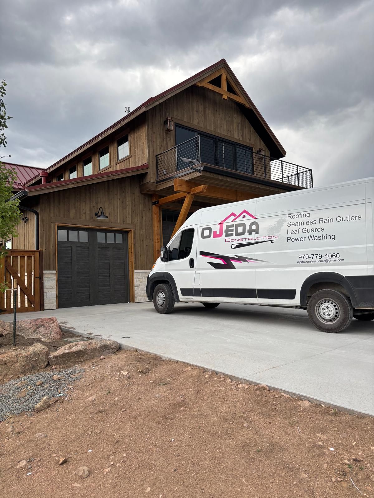 A black trailer is parked in front of a house.