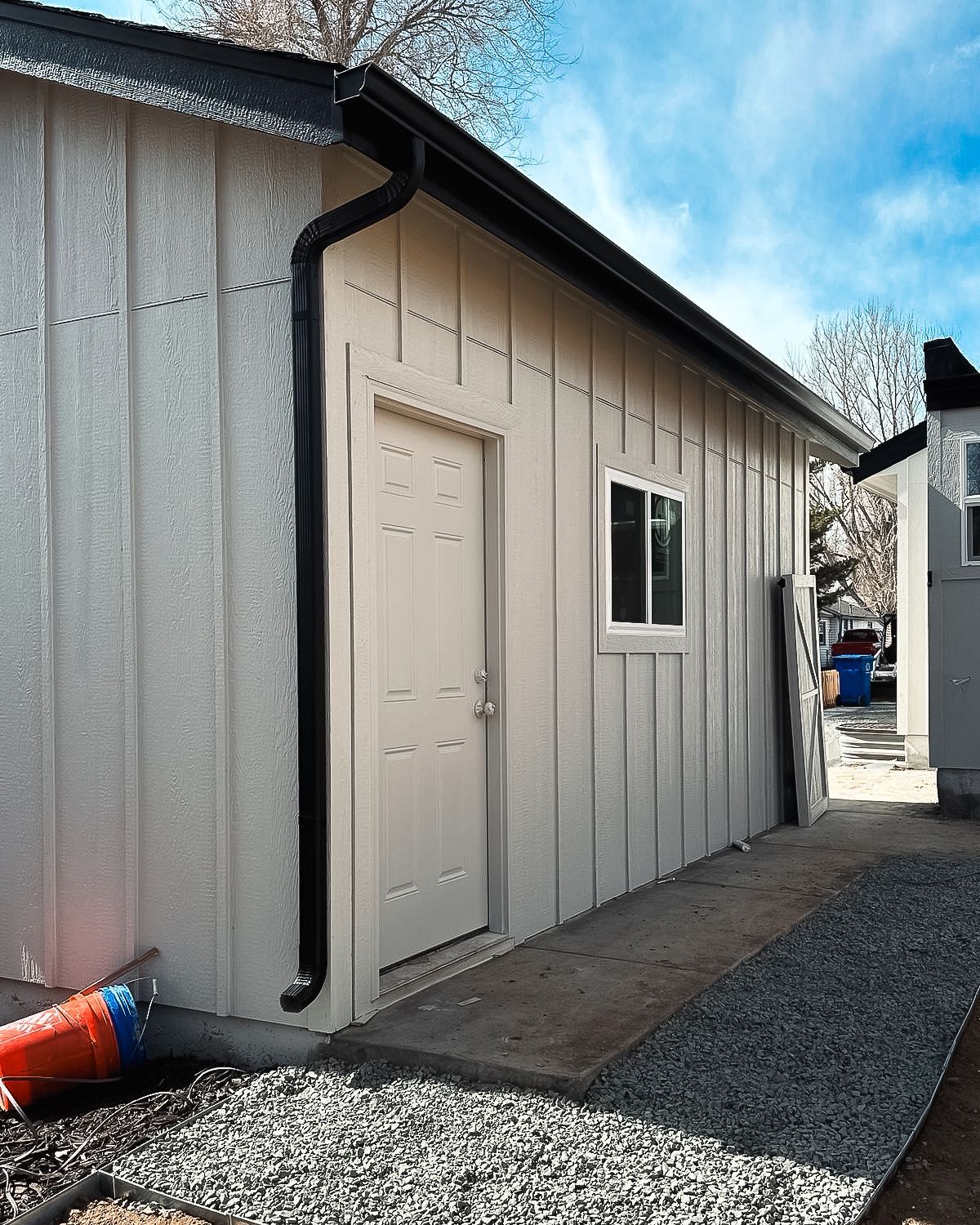 A white building with a black gutter and a door