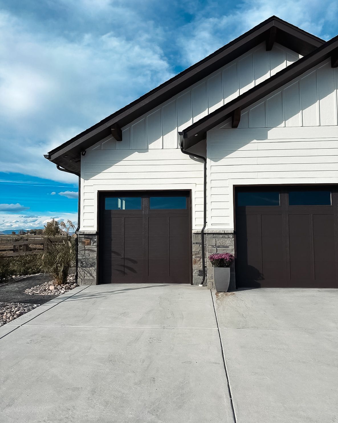 A house with two garage doors and a concrete driveway