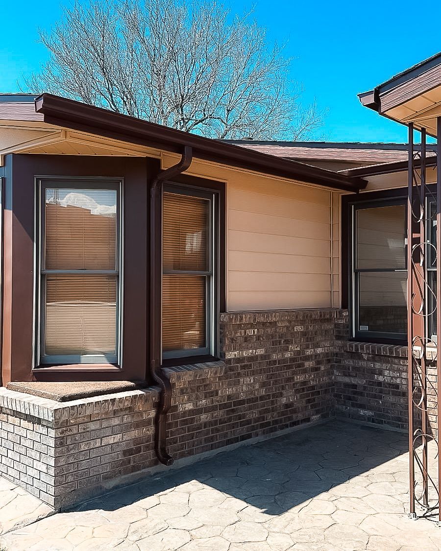 A house with a lot of windows and a brick wall