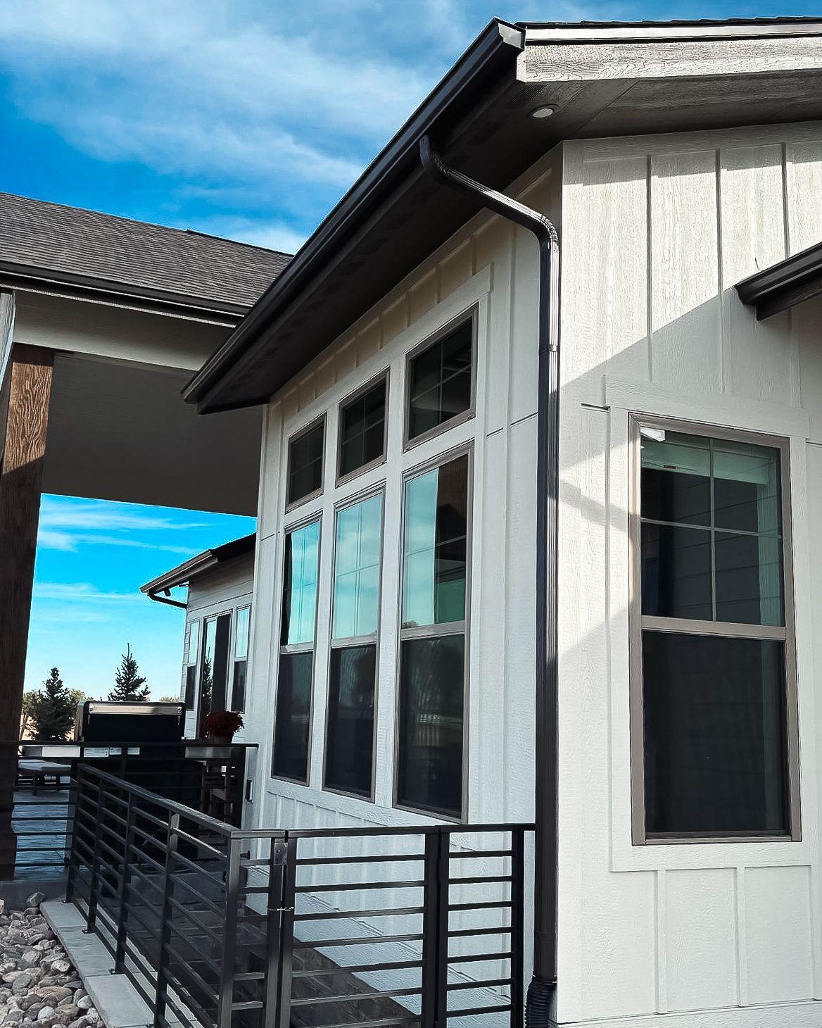 A white house with many windows and a black railing