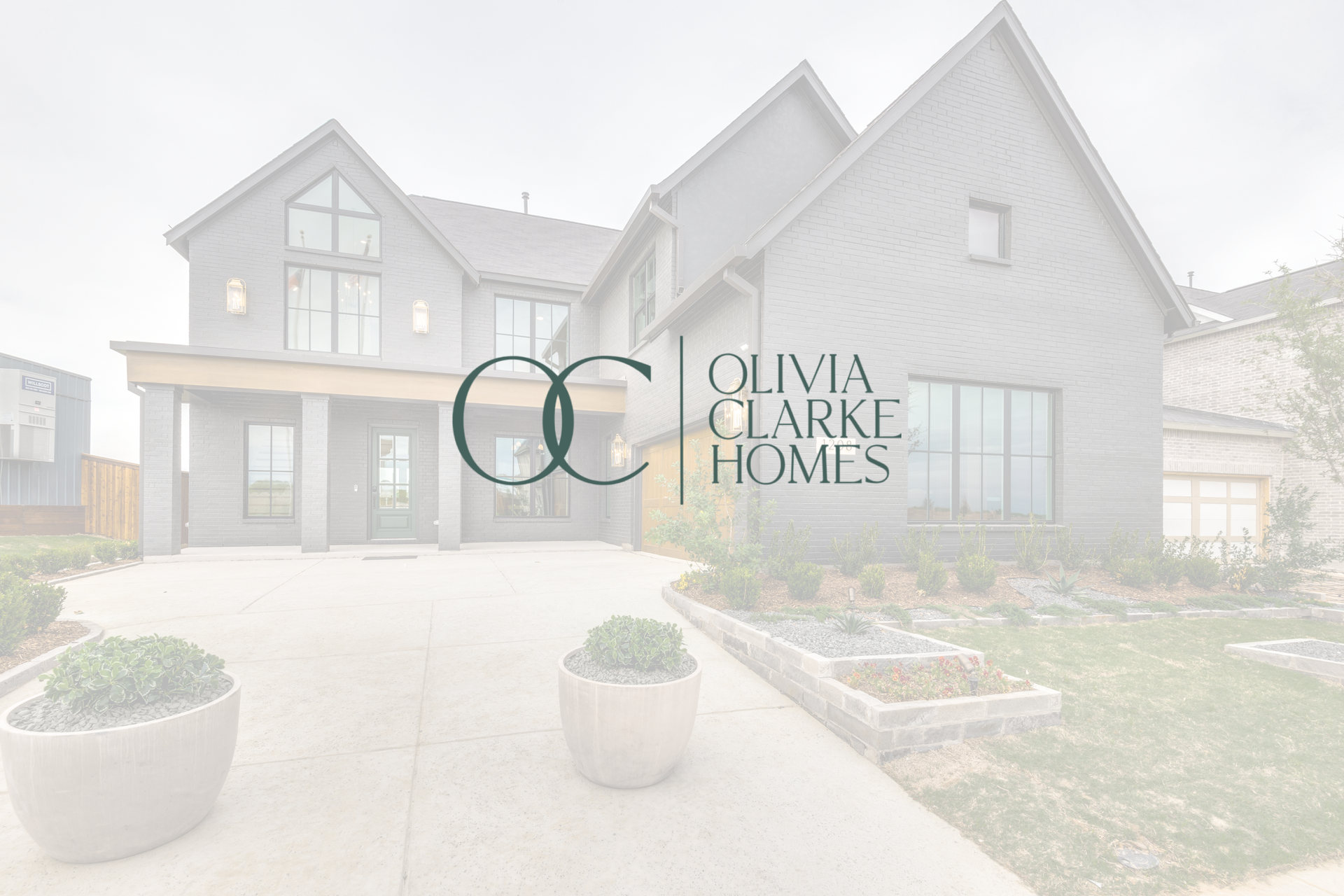 A large house with a logo for olivia clarke homes in front of it.