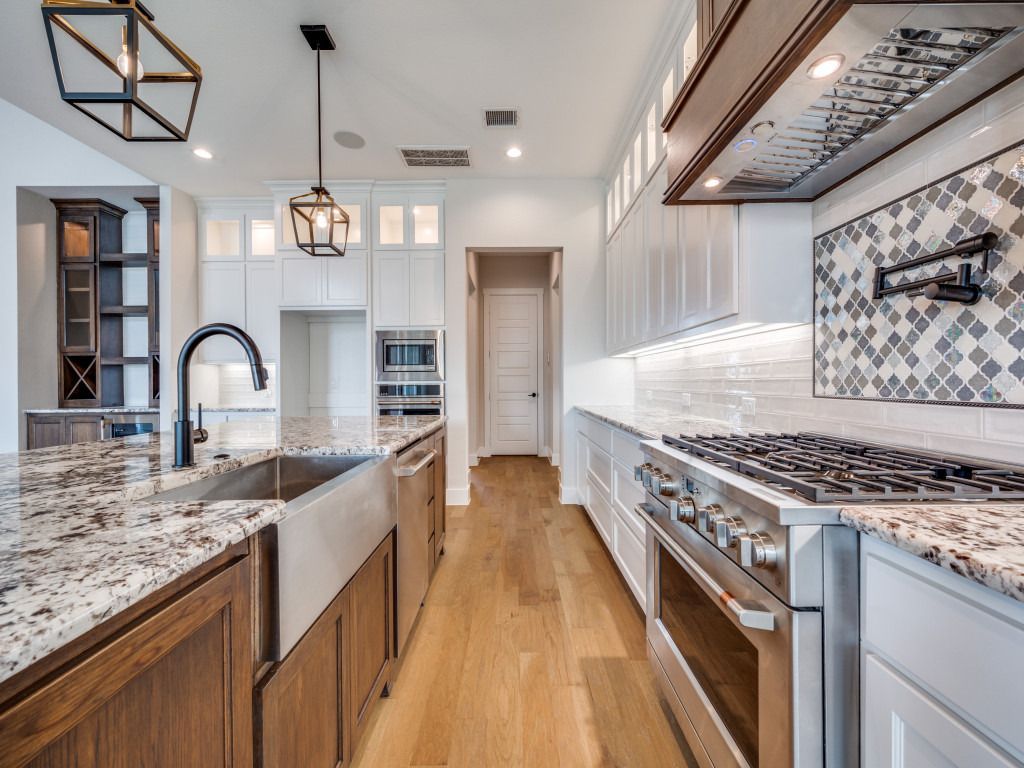 Spacious kitchen with a large island, white cabinets, and stainless steel appliances.
