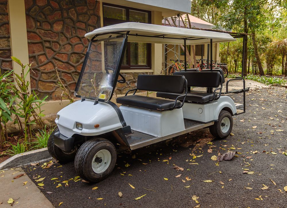 White Golf Cart Parked on a Paved Driveway Near a Building — Orange Auto Electrics in Orange, NSW