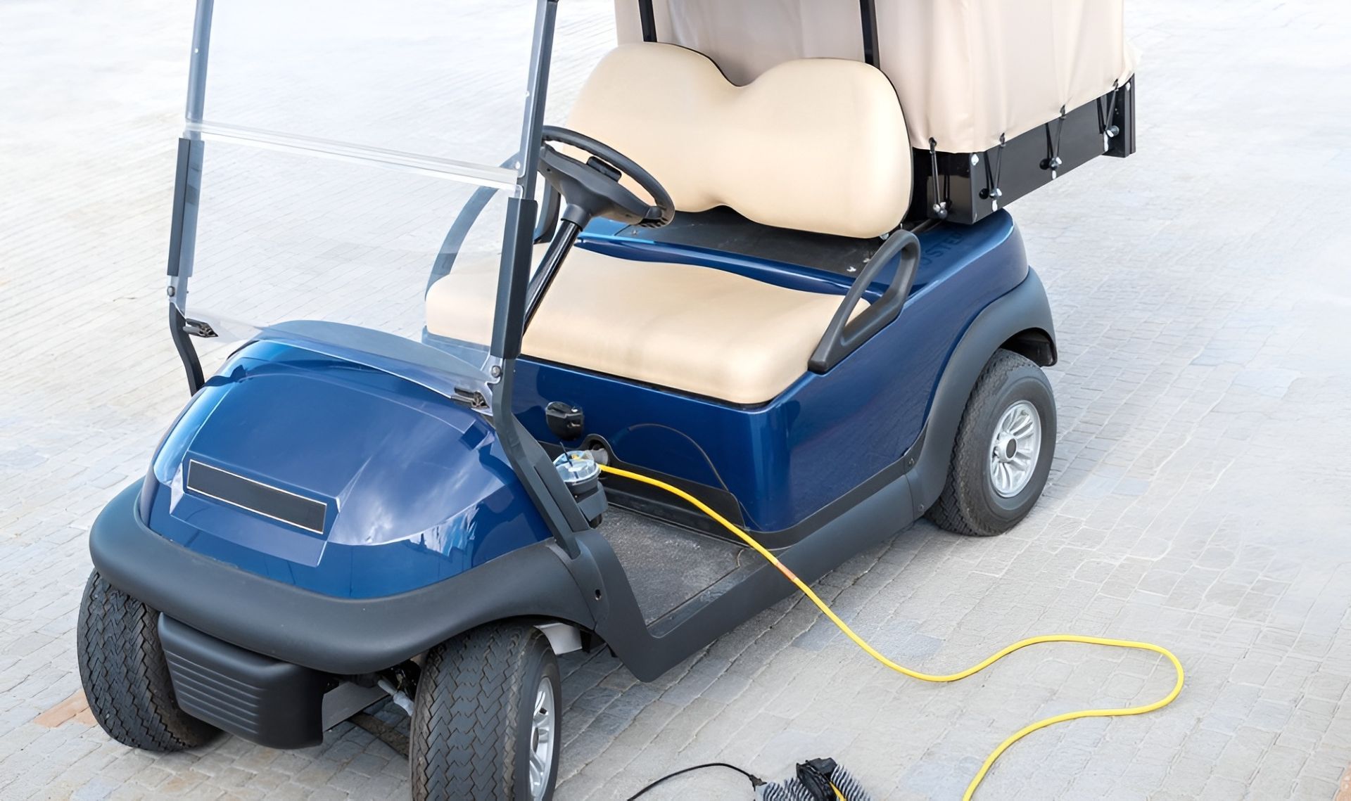 Blue Golf Cart Charging With Yellow Cable. Tan Seats and Roof — Orange Auto Electrics in Orange, NSW