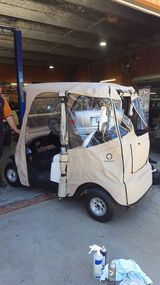 Tan Golf Cart With Clear Side Panels in a Garage — Orange Auto Electrics in Orange, NSW