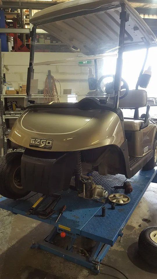 Gold Golf Cart on a Lift With Front Wheel Removed, in a Repair Shop — Orange Auto Electrics in Orange, NSW