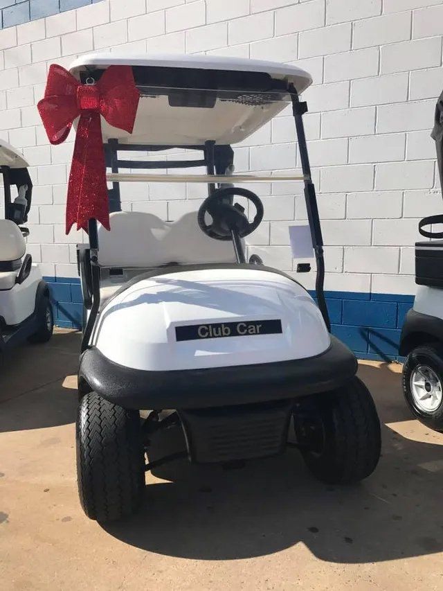 White Club Car Golf Cart With Red Bow, Parked in Front of a White Brick Wall — Orange Auto Electrics in Orange, NSW