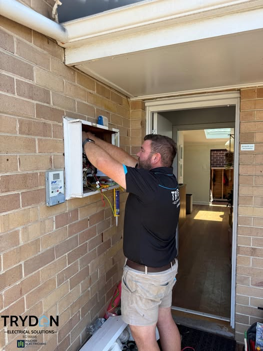 Smiling person in cap and overalls wiring a ceiling light fixture. Smiling person in cap and overalls wiring a ceiling light fixture.