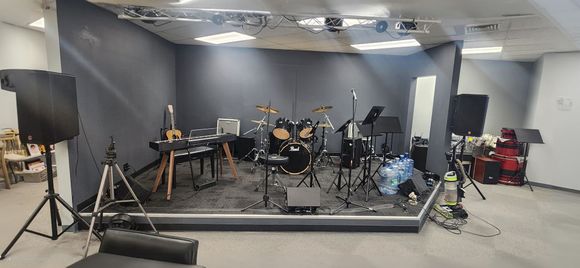 A room with a stage and a lot of musical instruments on it.