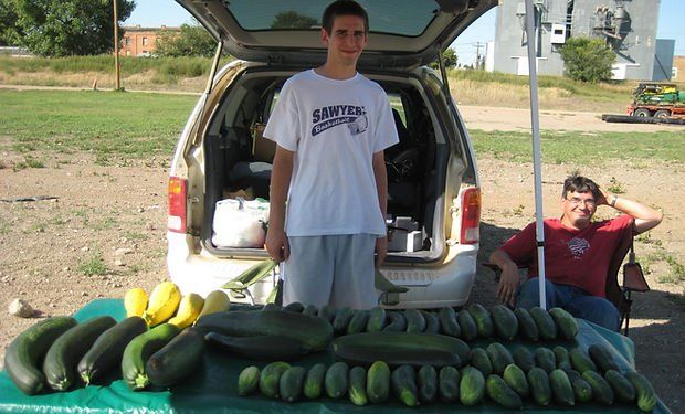 Young boy marketing his zucchini
