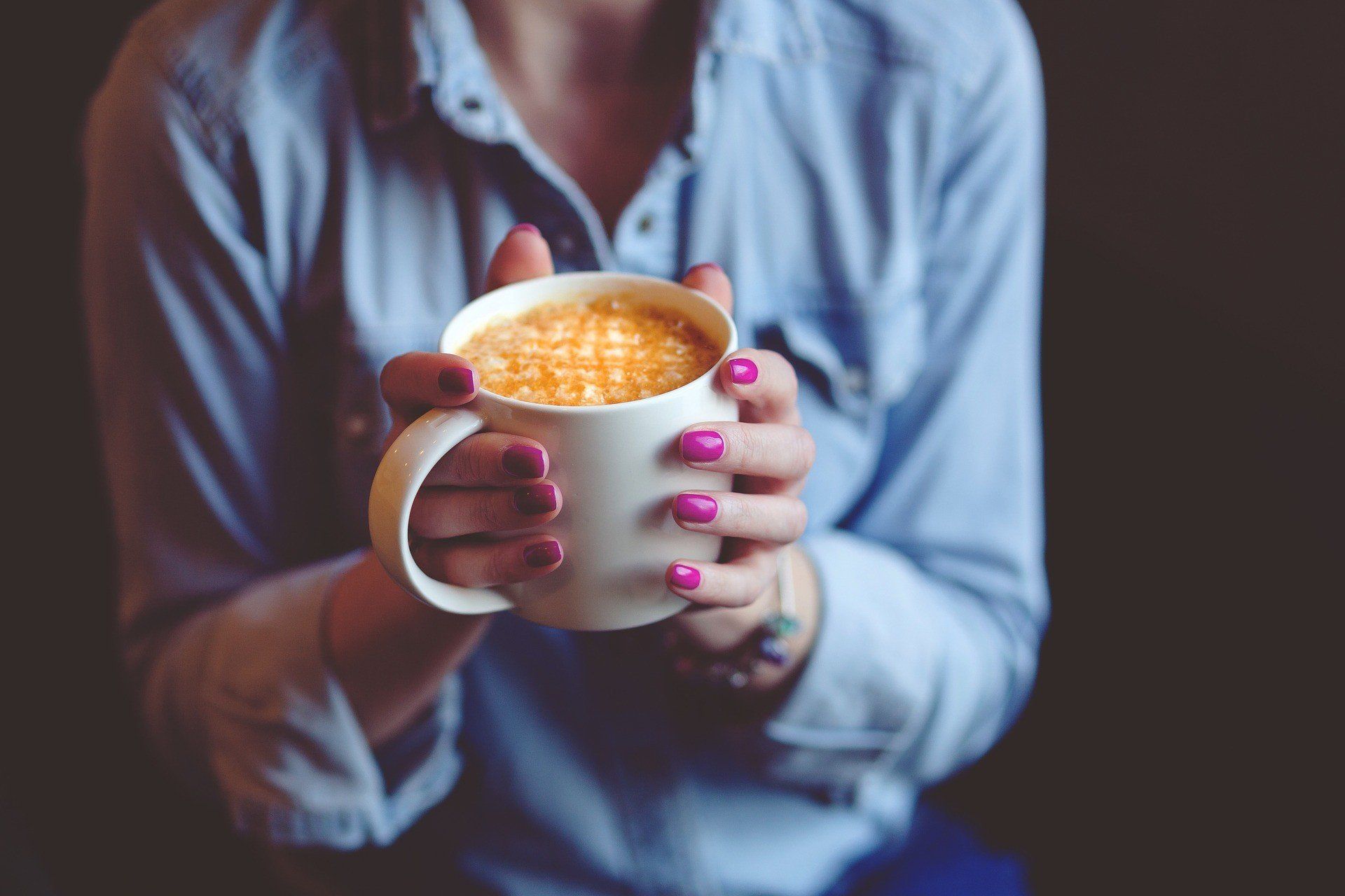 Woman with beautiful nails holding a cup of coffee