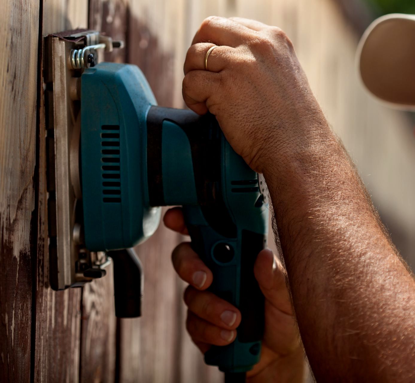 Buffing out a wooden fence for more repair maintenance
