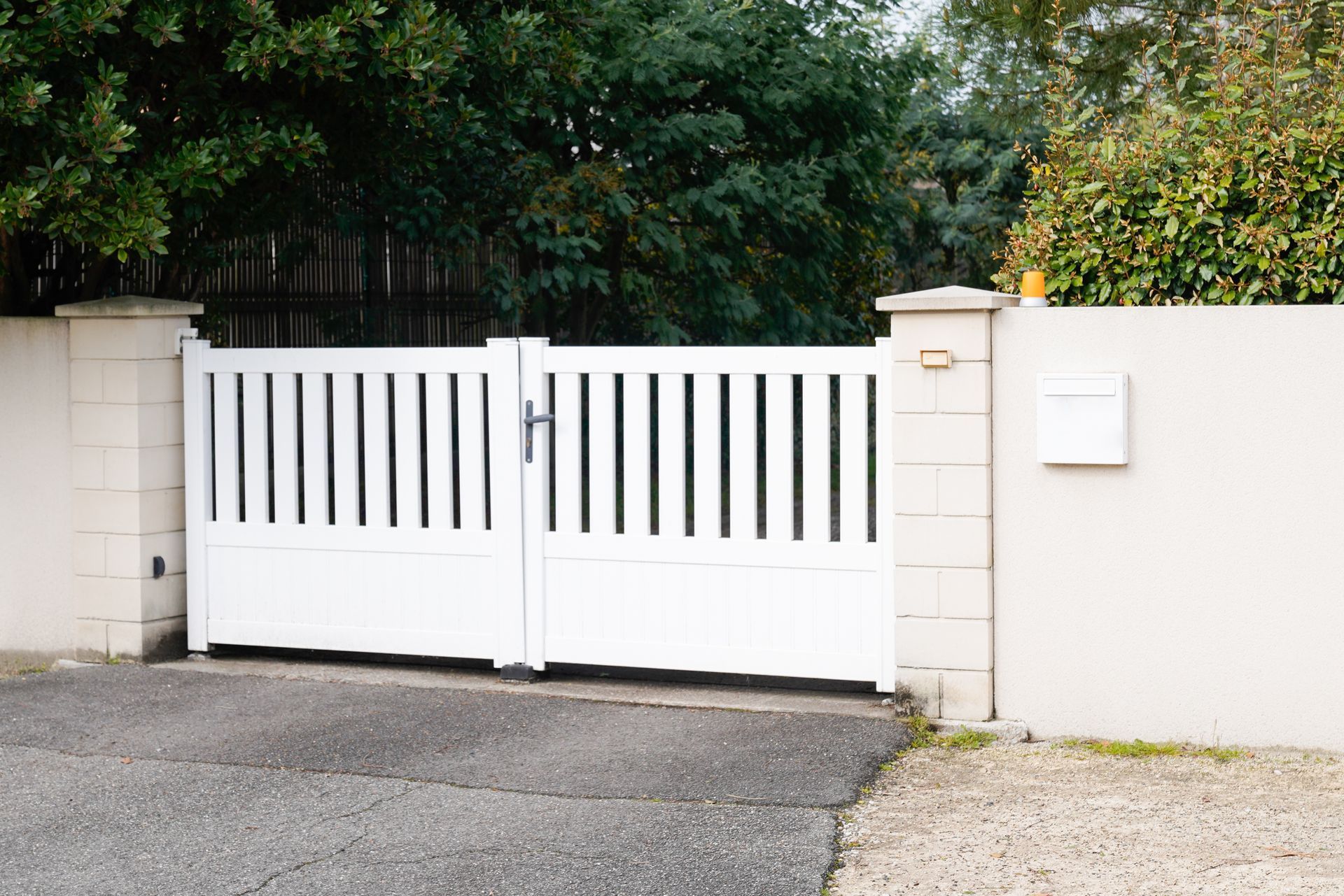 White swing gate with locking capabilities in the middle.
