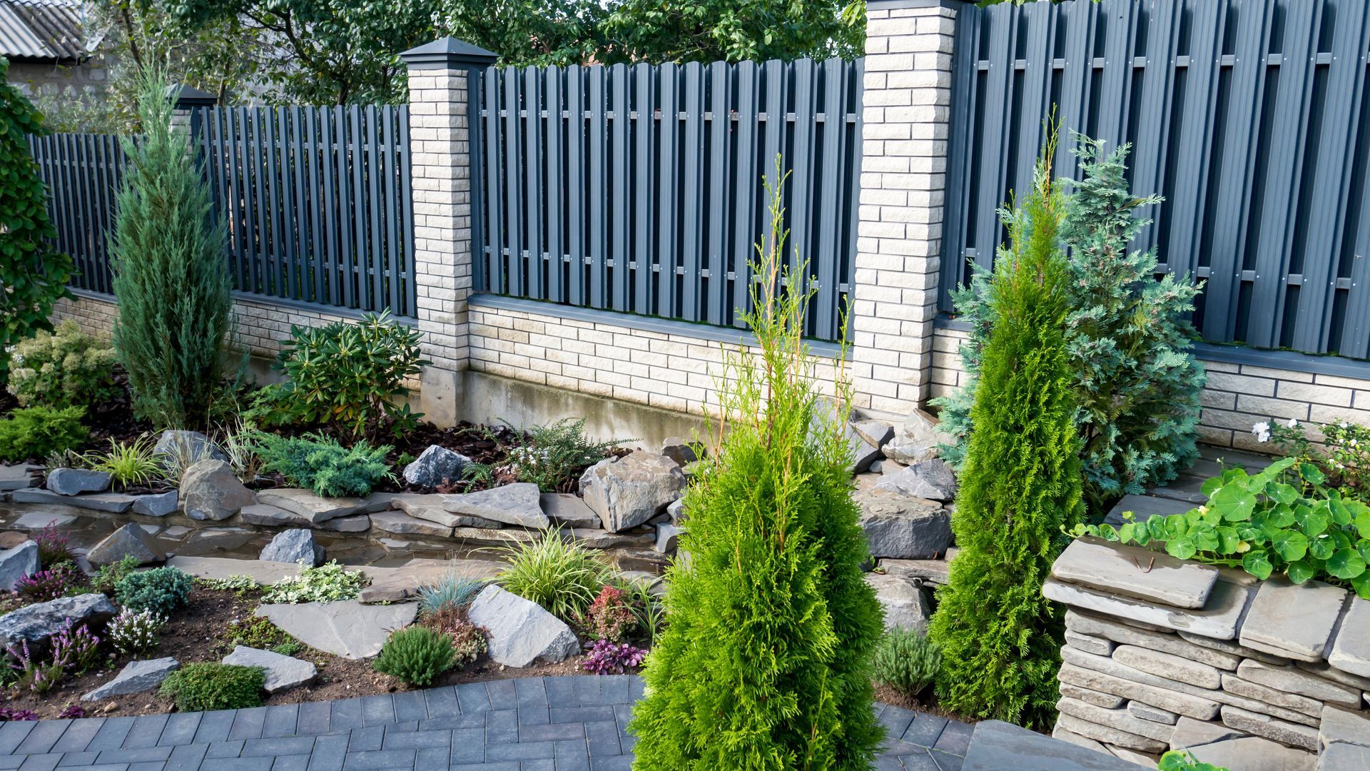 Blue stake fencing raised by stone hardscape structure