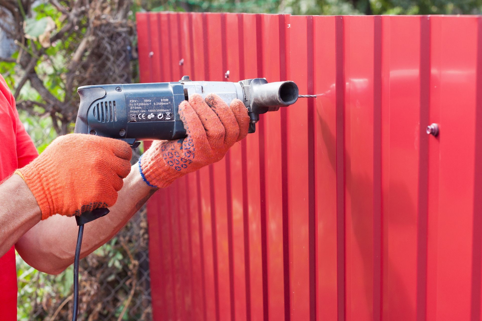 Reinforcing finishing touches on a red fence structure