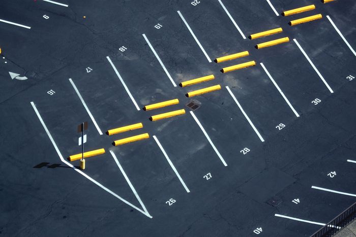 An aerial view of a parking lot with yellow poles and white lines