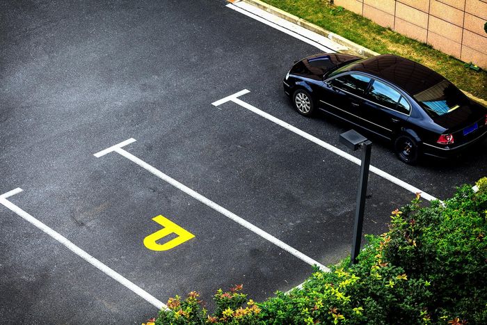 A black car is parked in a parking lot