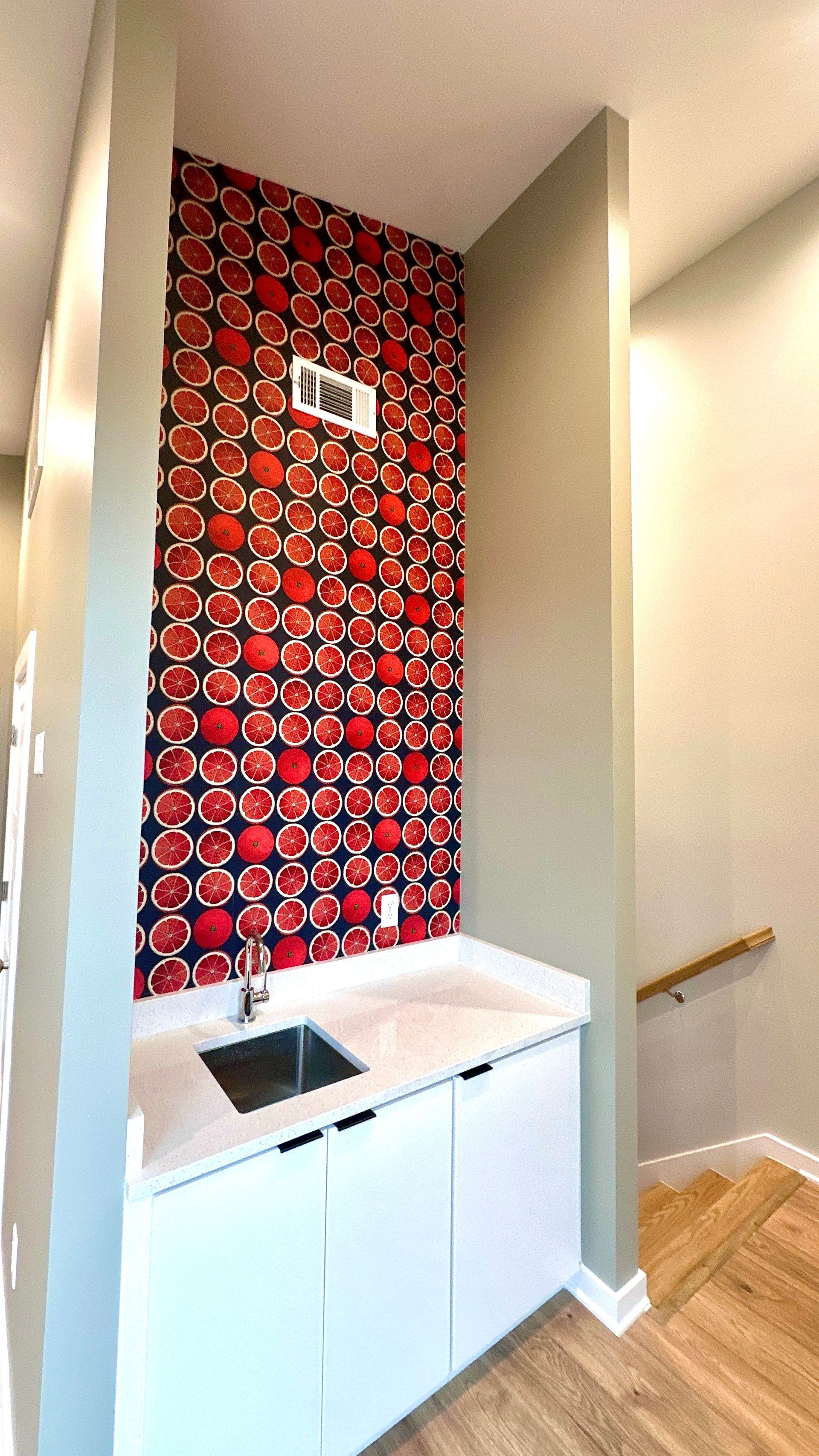A kitchen with a sink and a red and blue wallpaper on the wall in Nashville, TN