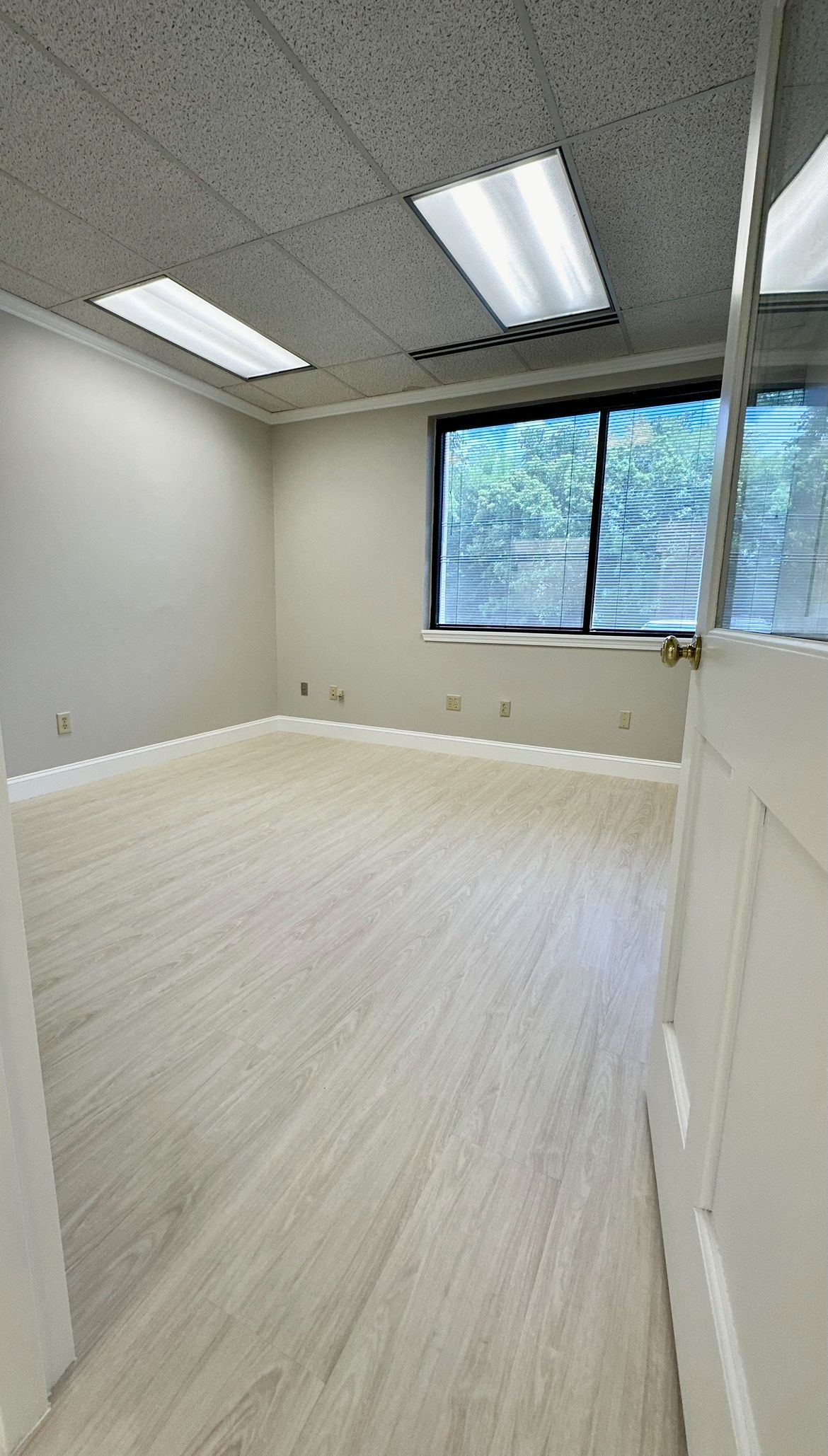 An empty room with a wooden floor and a window.