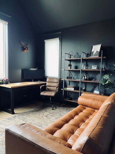 A bedroom with a bed , chairs , lamps and a ceiling fan.