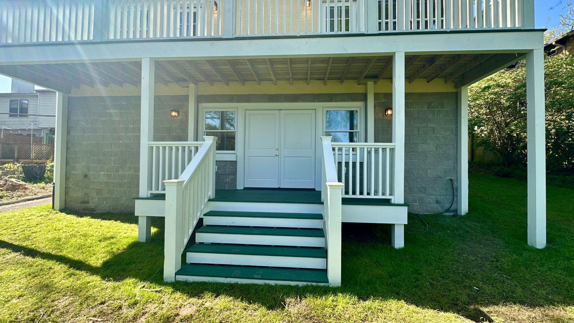 The front of a house with a porch and stairs leading up to it.