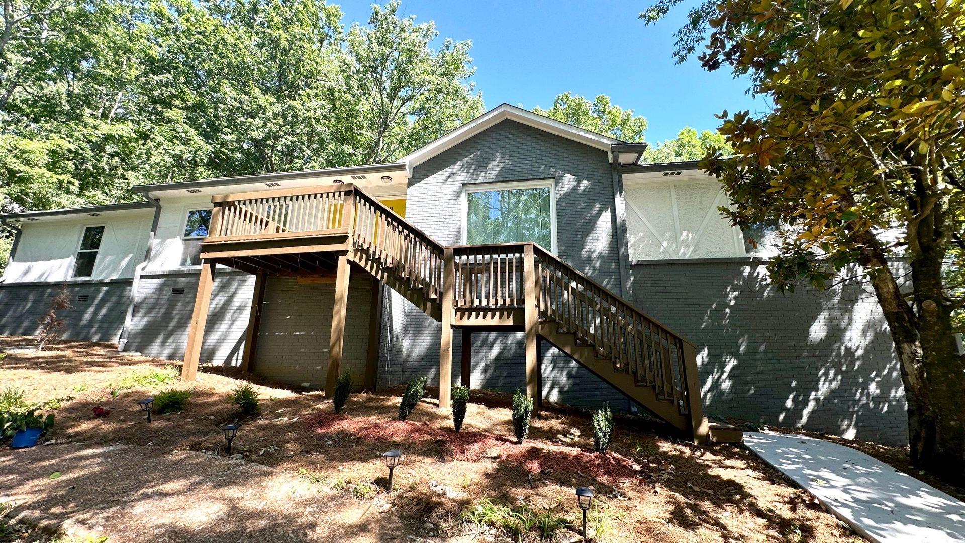A house with a large deck and stairs leading up to it.