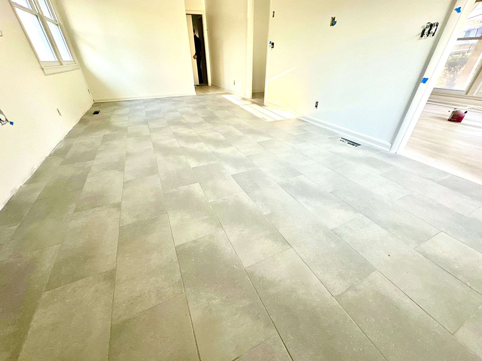 A room with a gray tile floor and white walls.