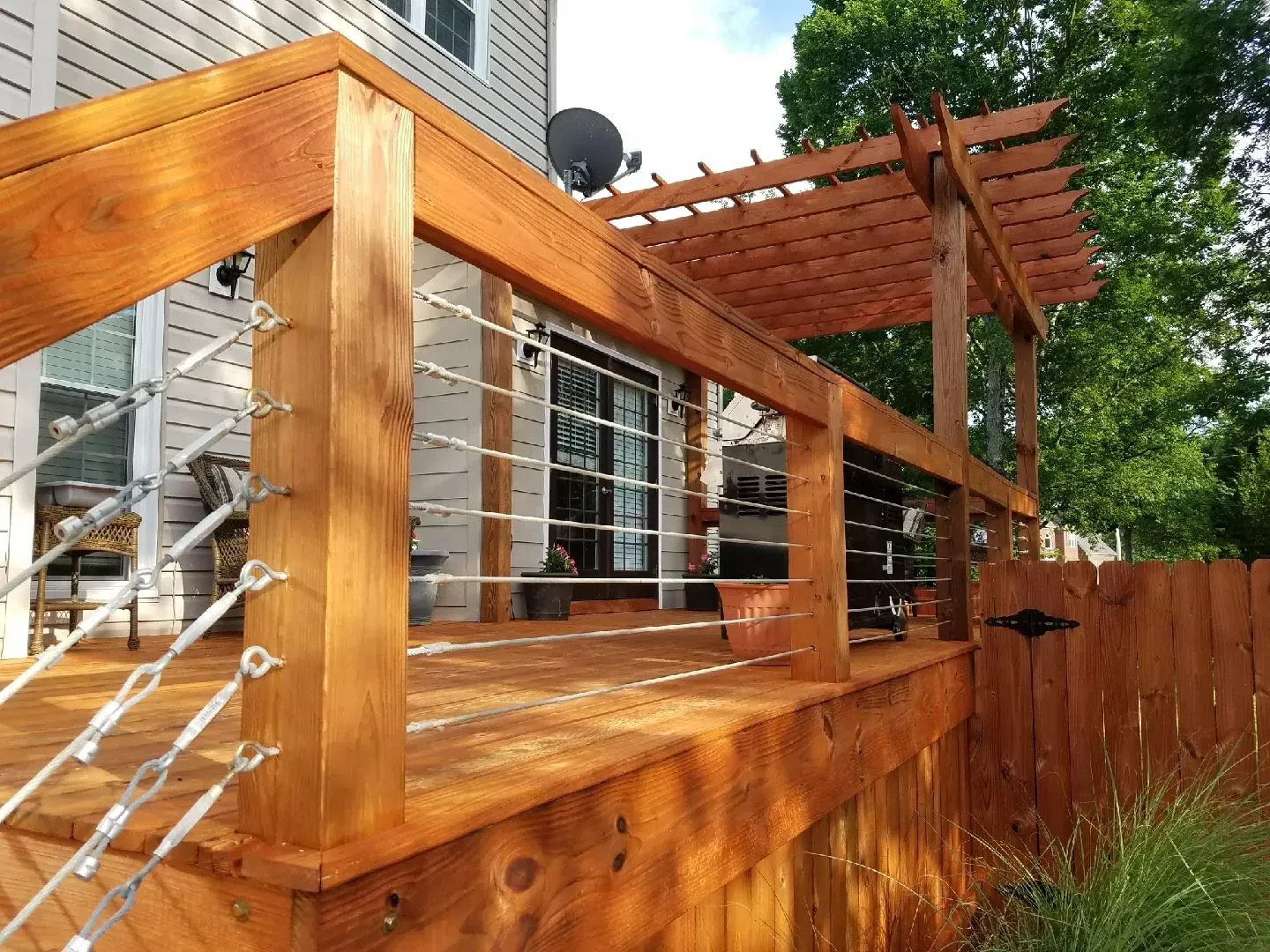 A wooden deck with a pergola and stairs