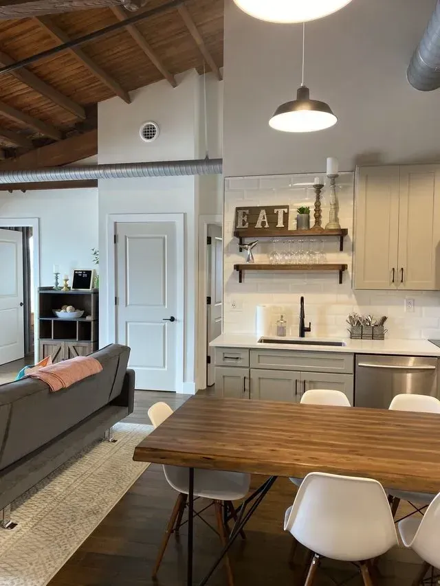 home remodeling nashville tn A kitchen with a wooden table and chairs and a sign that says eat on the wall.