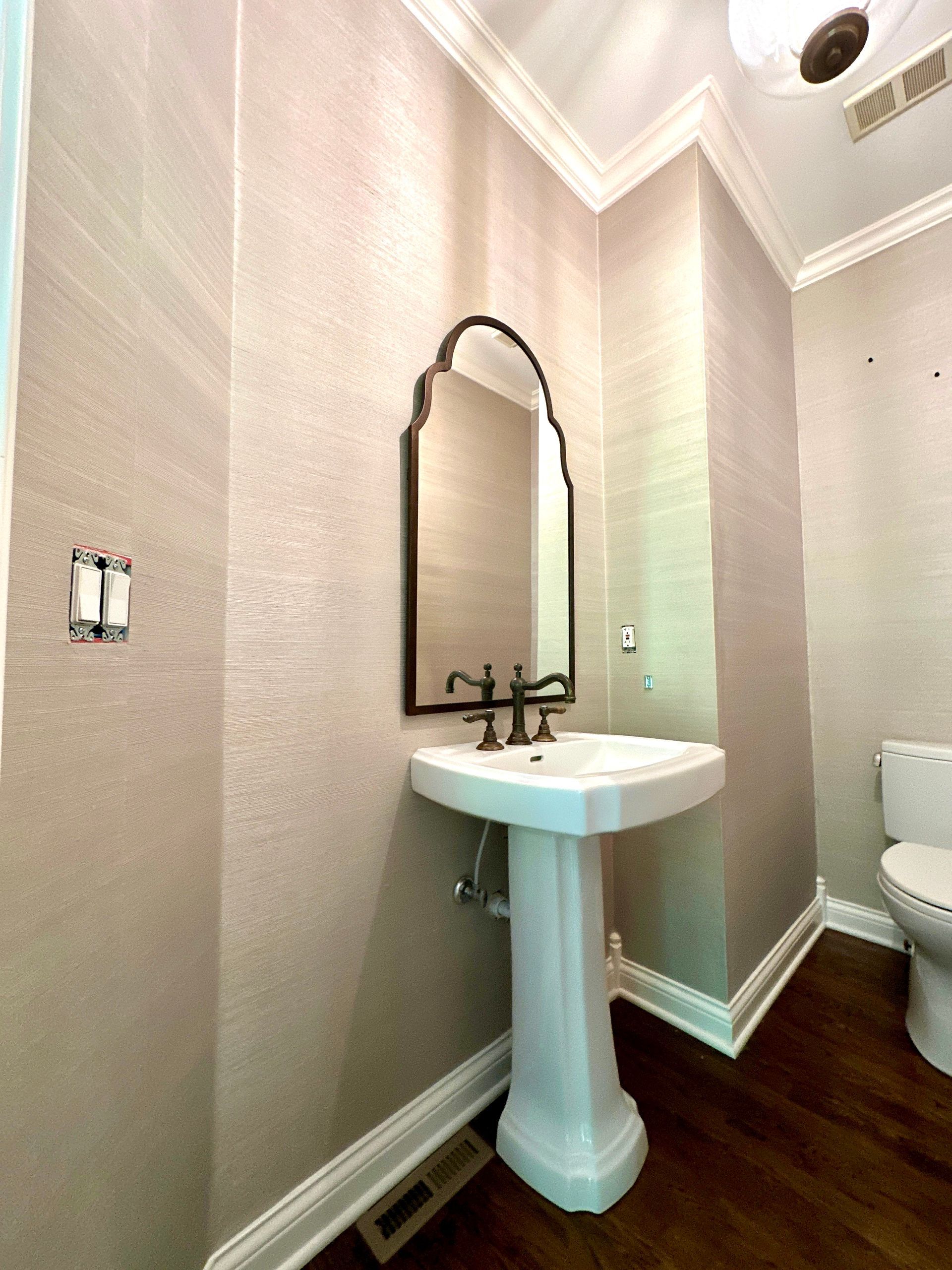 A bathroom with a pedestal sink and a toilet