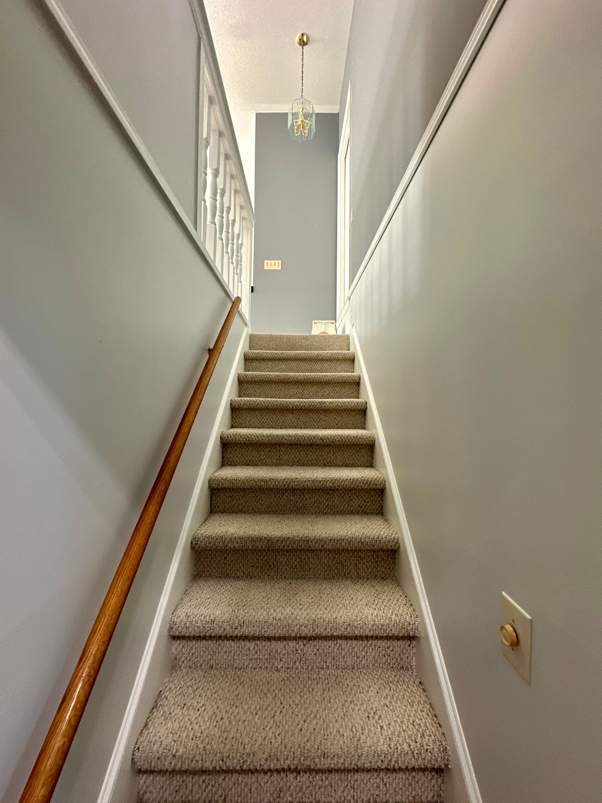 A staircase with carpeted steps and a wooden railing in Nashville, TN