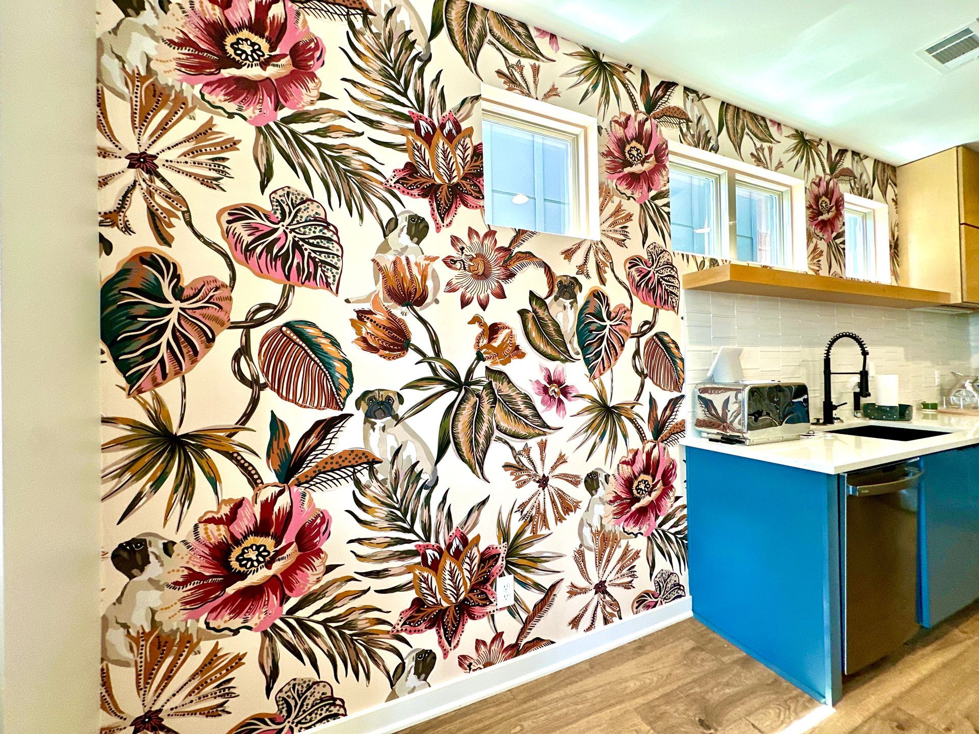 A kitchen with a large floral wallpaper on the wall.