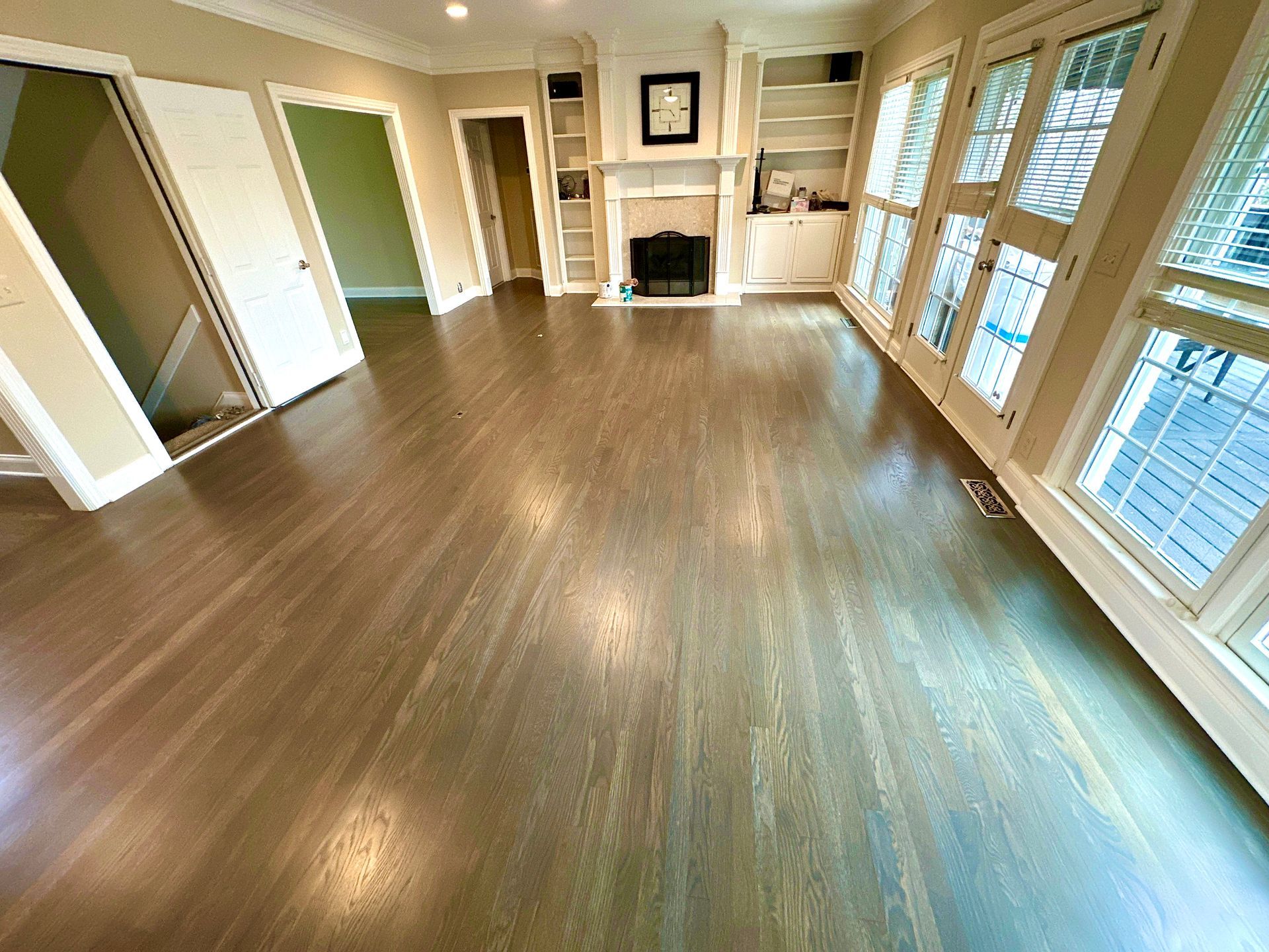 An empty living room with hardwood floors and a fireplace.