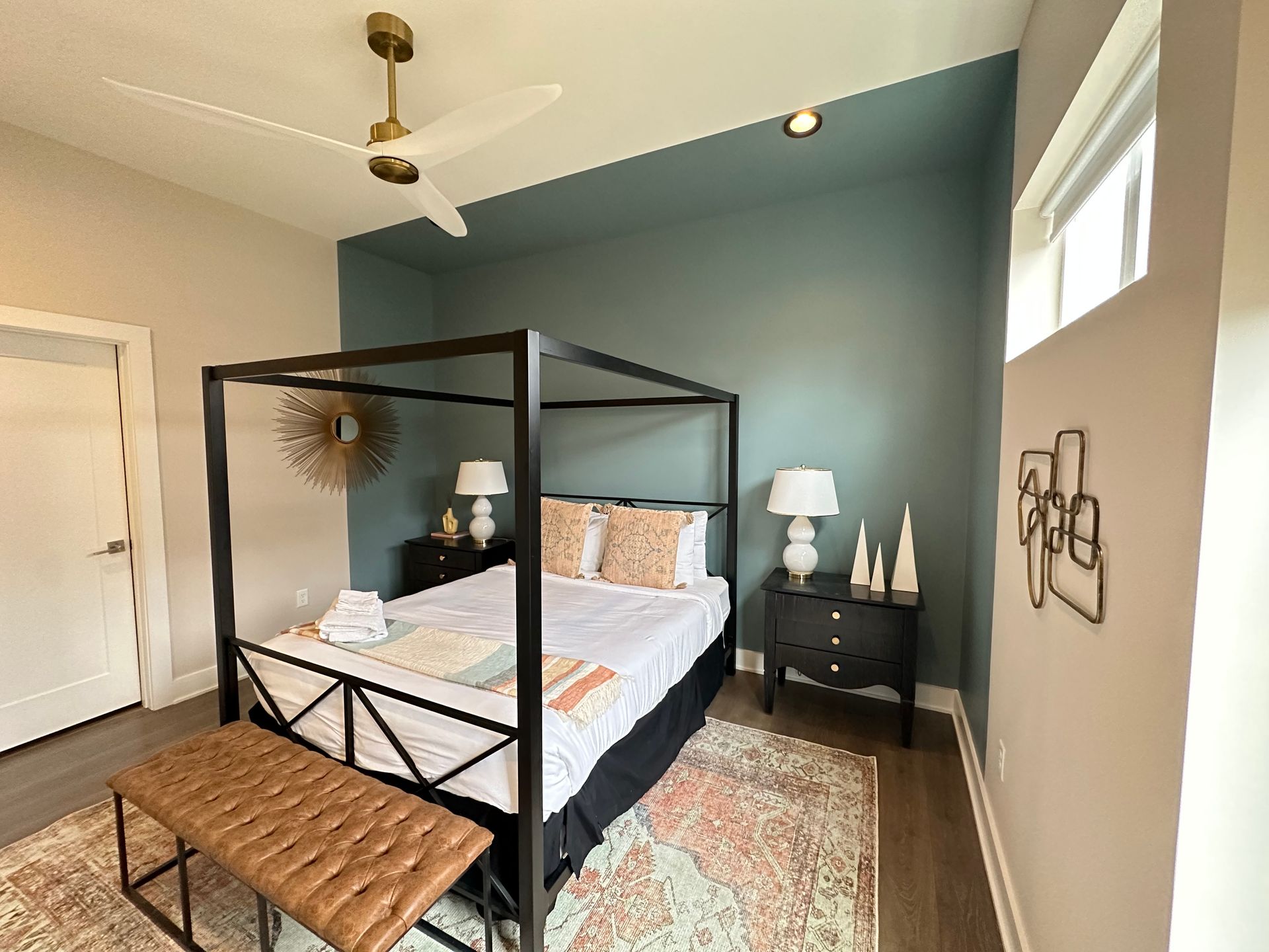 A bedroom with a canopy bed and a ceiling fan.