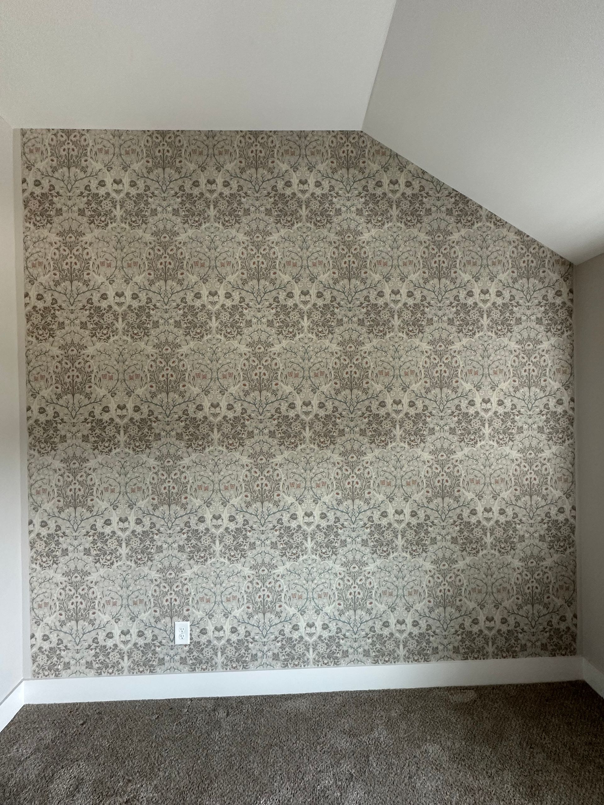 A room with a slanted ceiling and a patterned wallpaper on the wall in Nashville, TN