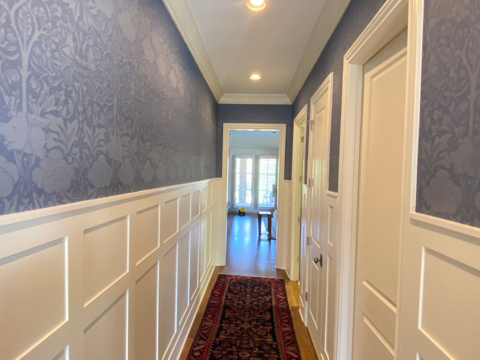 A hallway with blue walls and white trim and a rug in Nashville, TN