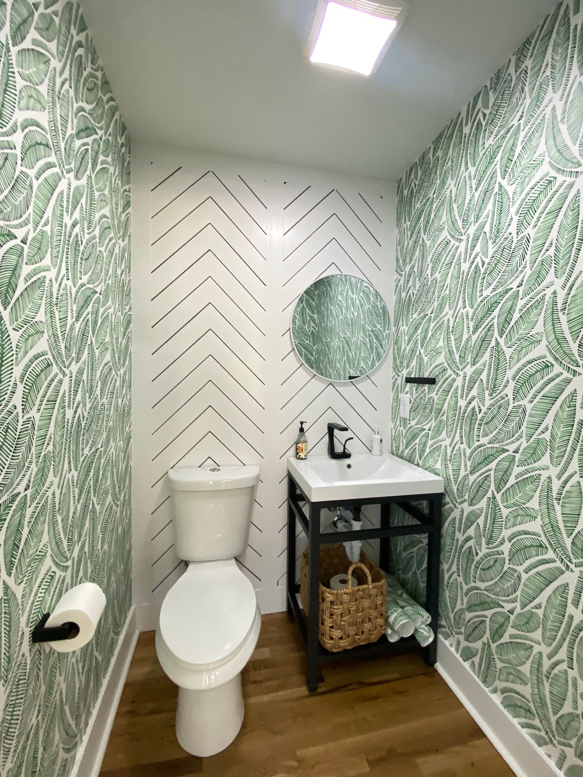 A bathroom with a toilet , sink and mirror.